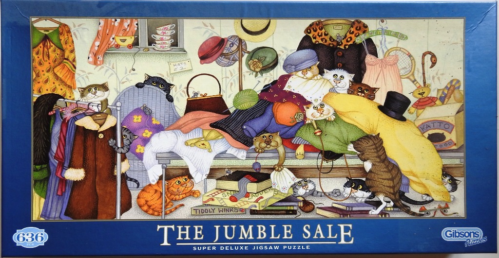 Cartoon illustration of many cats playing and hiding among piles of clothes and household items at a jumble sale.