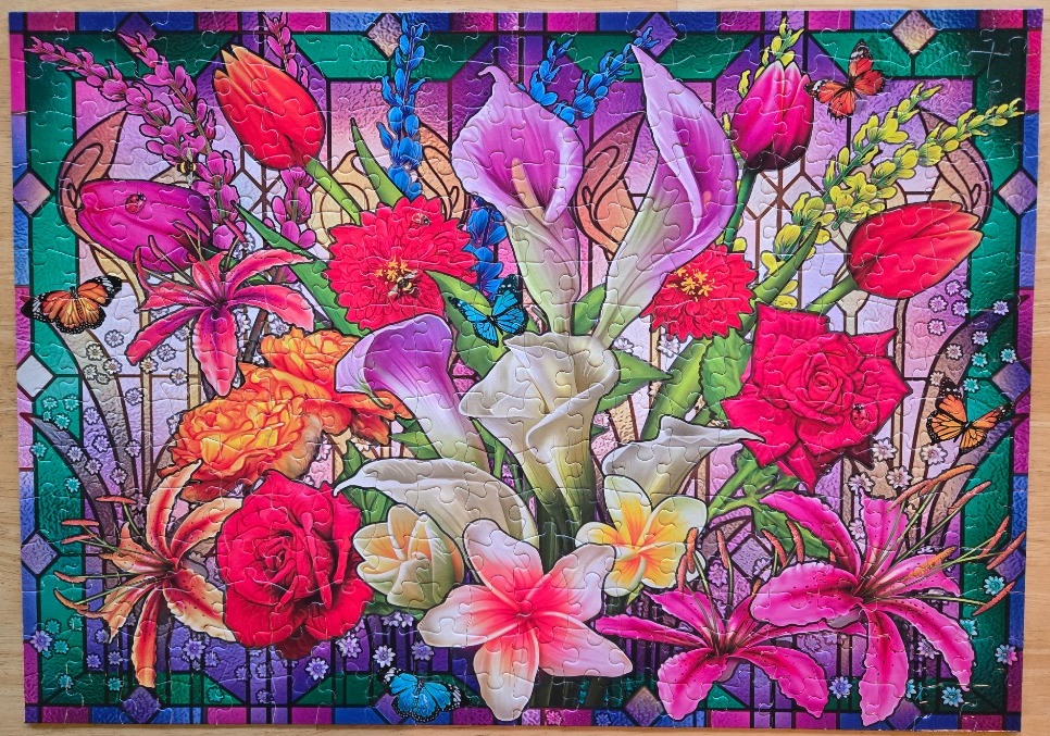 Stained glass style illustration of a vibrant floral arrangement with lilies, tulips, roses, and butterflies.
