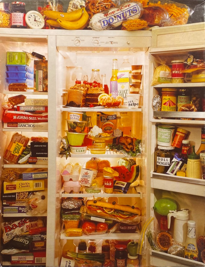 A refrigerator completely overflowing with a chaotic, colorful collection of food, drinks, and snacks.