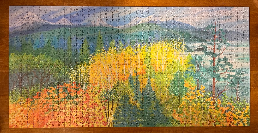 An impressionistic landscape painting of an autumn forest overlooking a misty lake and mountains.