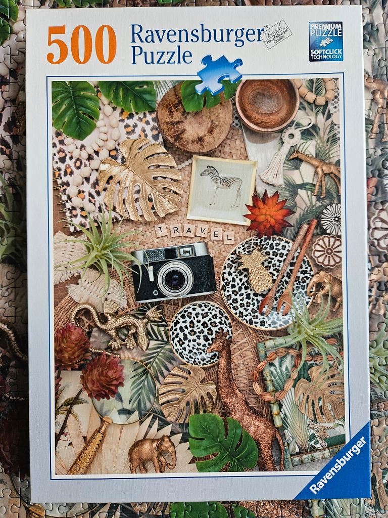 A flat-lay photograph featuring safari-themed decor items including animal figurines, leopard print, and tropical leaves.