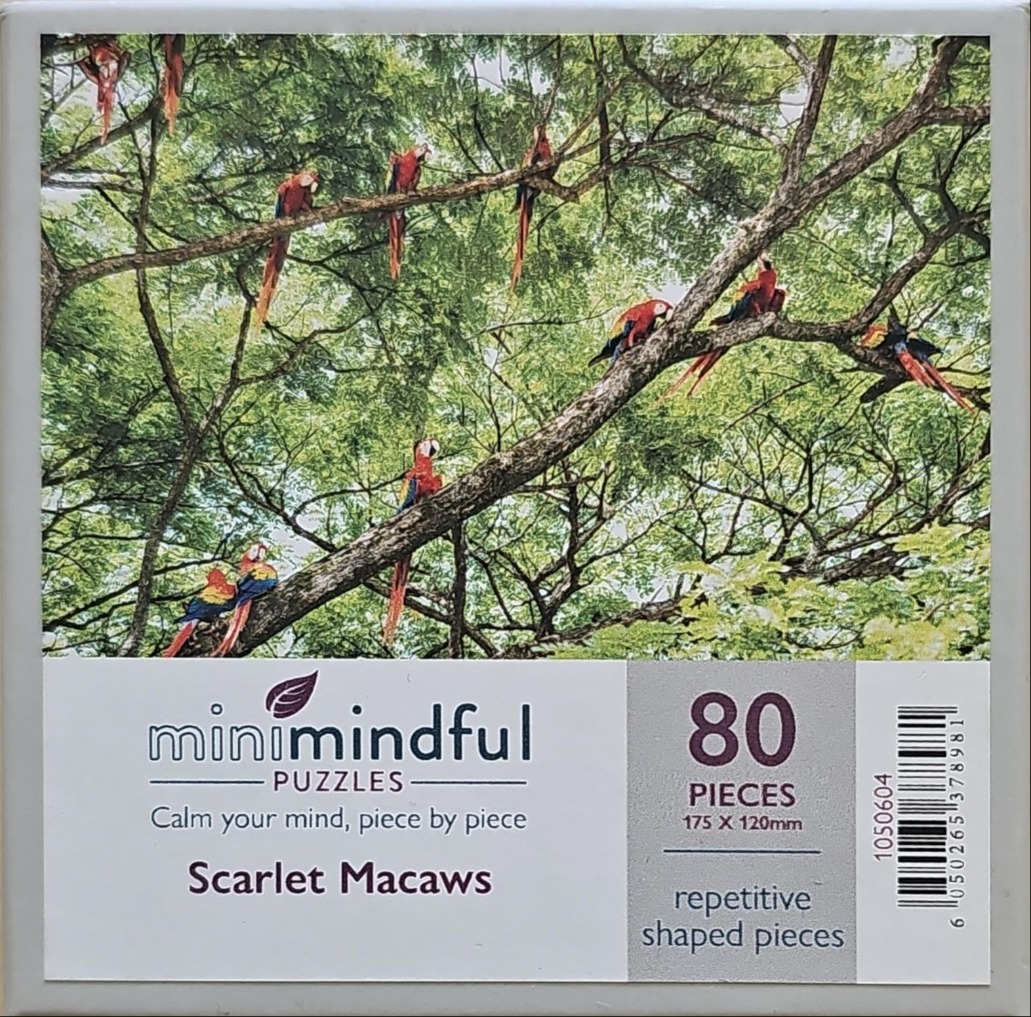 A flock of scarlet macaws perched on the branches of a lush green tree.