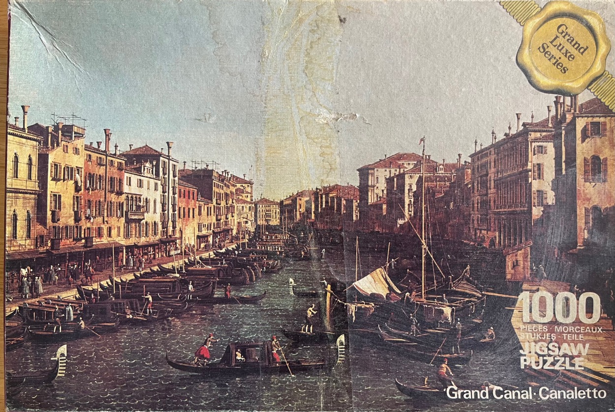 A Canaletto painting of the Grand Canal in Venice featuring gondolas and historic buildings