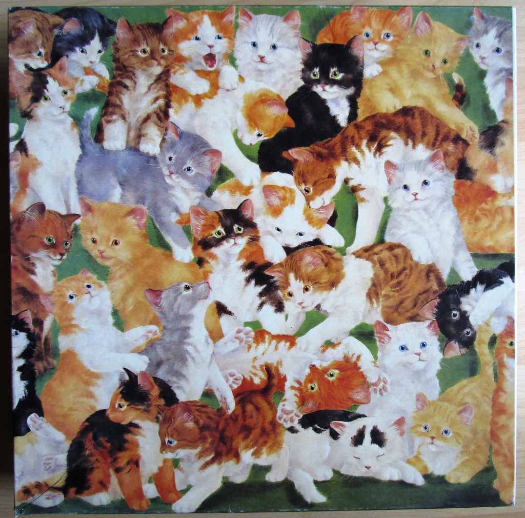A dense cluster of many fluffy kittens of various breeds and colours on a green background.