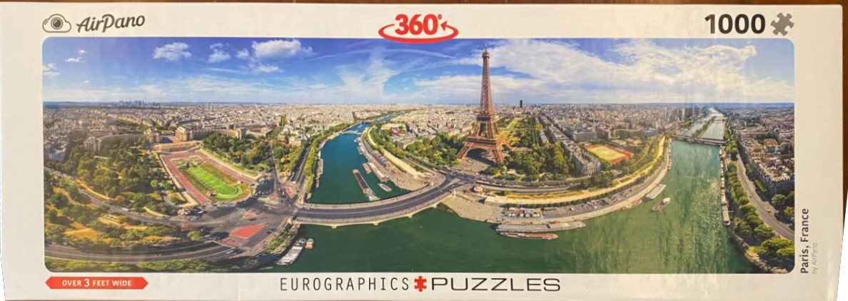 Panoramic aerial view of the Eiffel Tower and the Seine River in Paris, France under a clear blue sky.