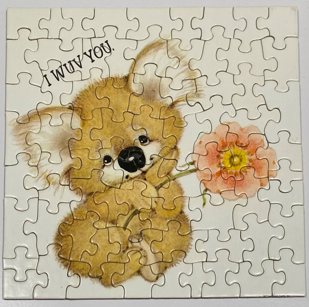 A vintage-style illustration of a cute, fluffy koala holding a peach-coloured flower, with the text I WUV YOU.