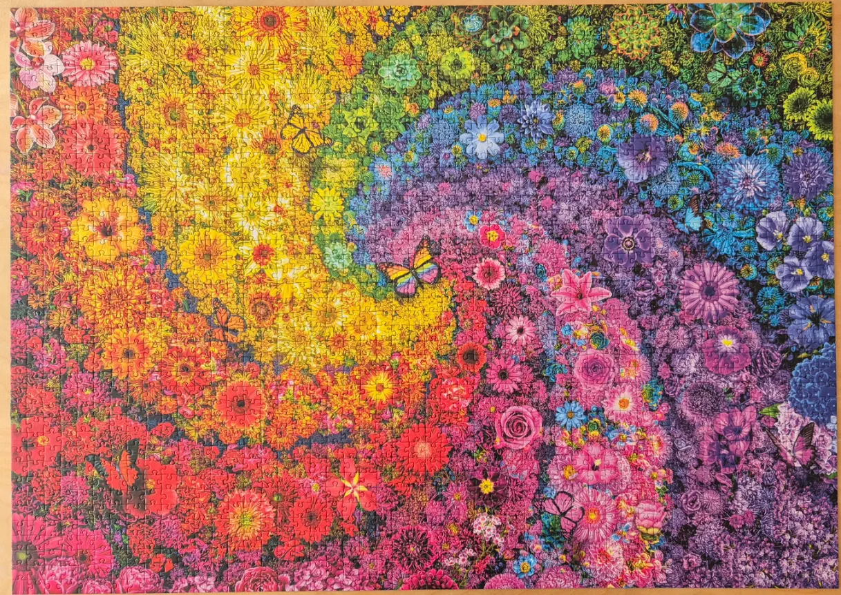A vibrant, rainbow-colored spiral arrangement of various flowers and butterflies.