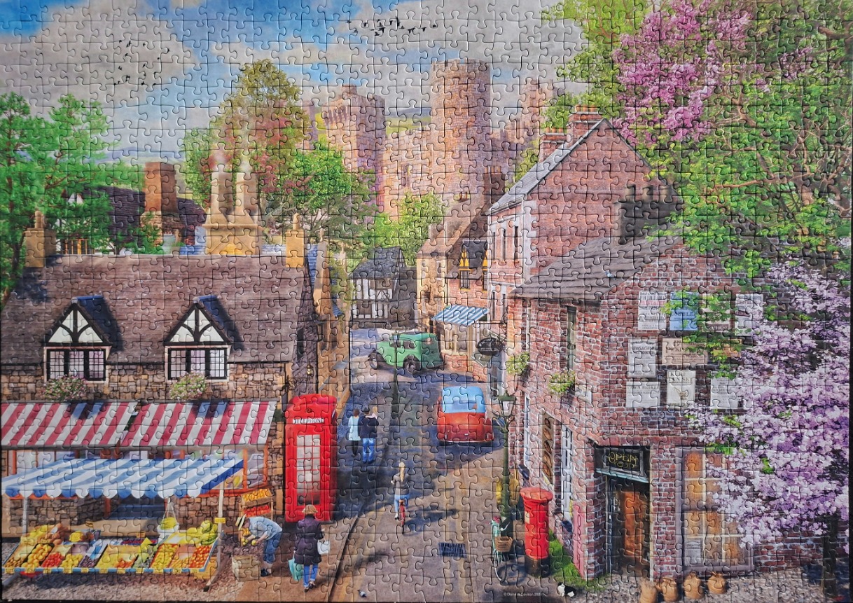 A charming English village scene with a greengrocer, a red phone box, and a stone castle in the distance.