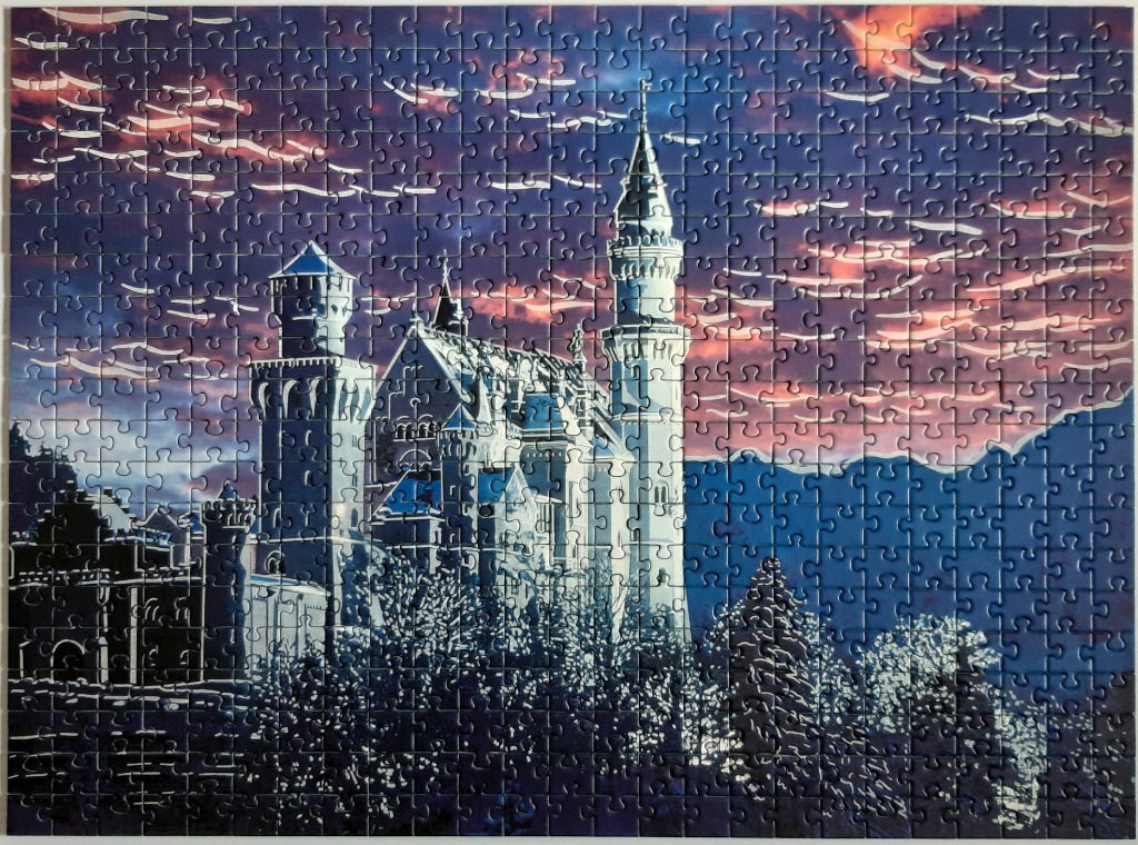 Neuschwanstein Castle at dusk with a dramatic, sunset-streaked sky.