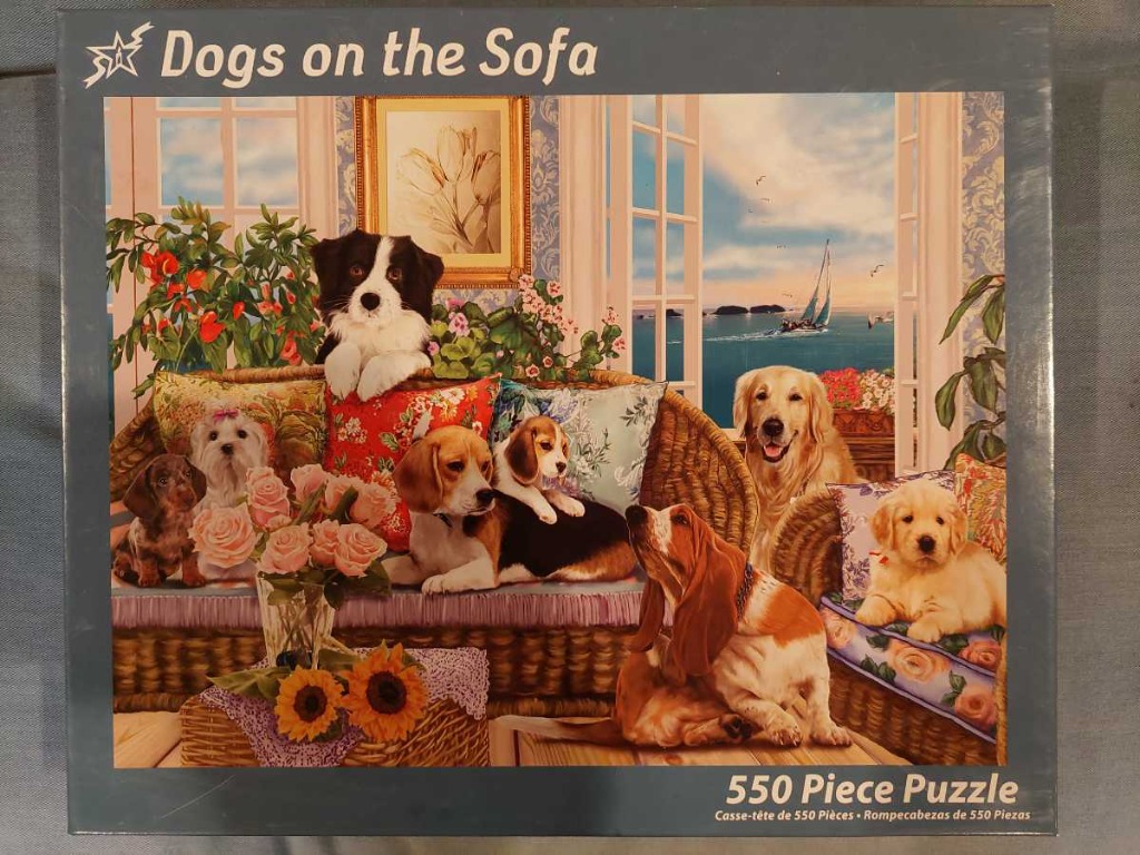Illustration of seven various dog breeds lounging on a wicker sofa in a room with a seaside view.
