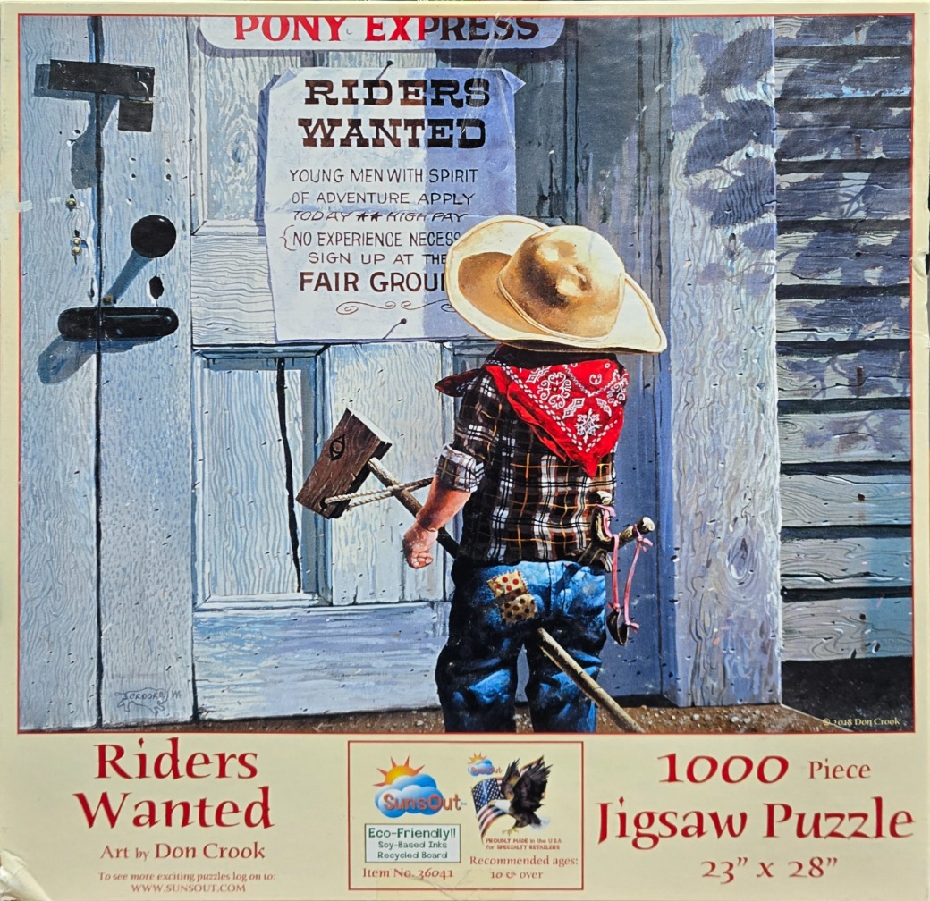 A young child dressed as a cowboy reading a Riders Wanted sign on a wooden door.