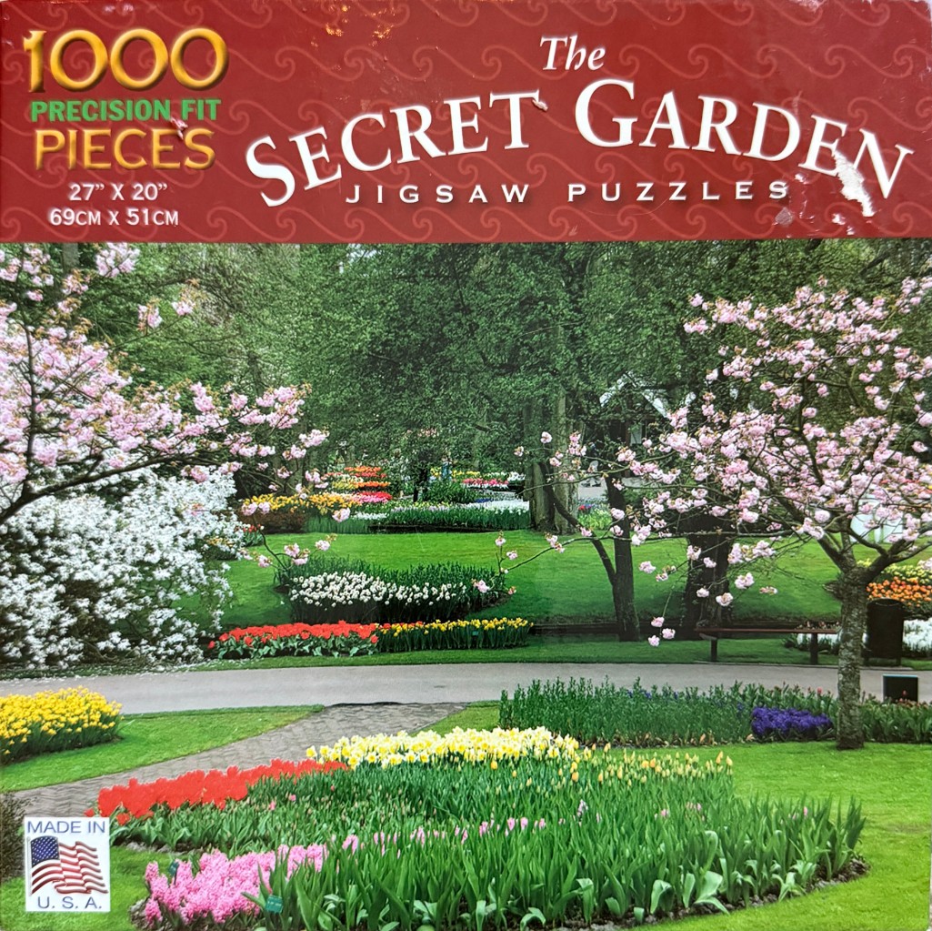 A lush spring garden with pink cherry blossoms, tulips, and vibrant flower beds surrounding a green lawn.