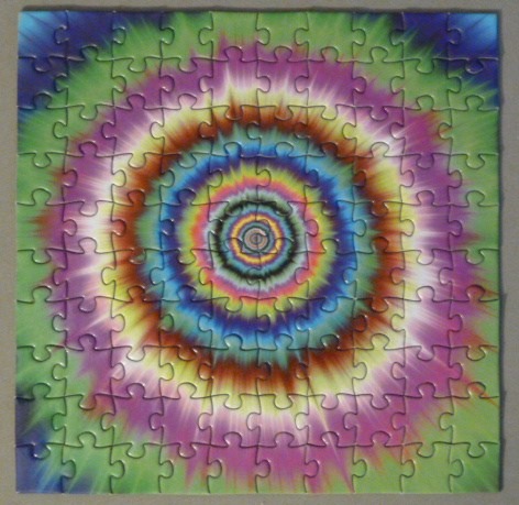 Abstract tie-dye pattern with concentric circles radiating from the center in vibrant colors.