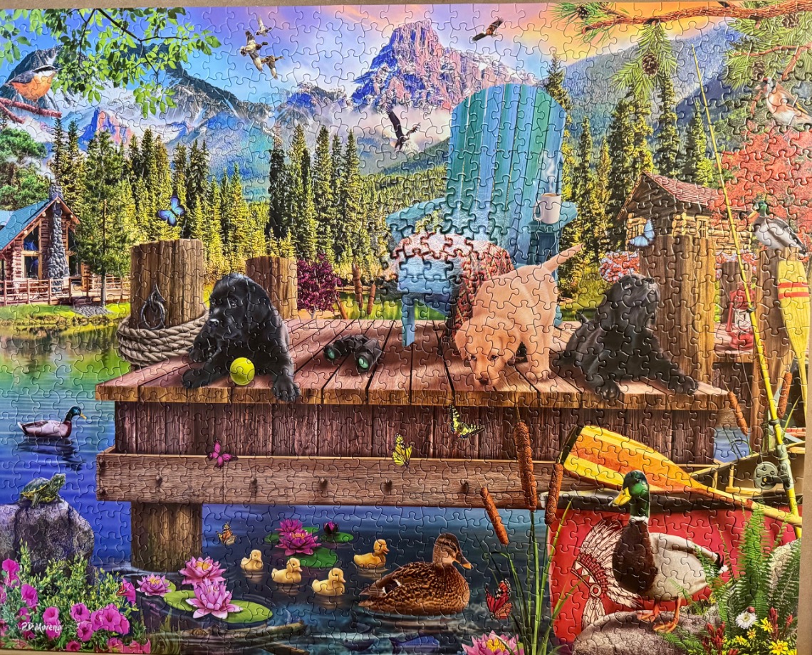A peaceful lakeside scene featuring three puppies, a blue chair, and wildlife in a mountain setting.