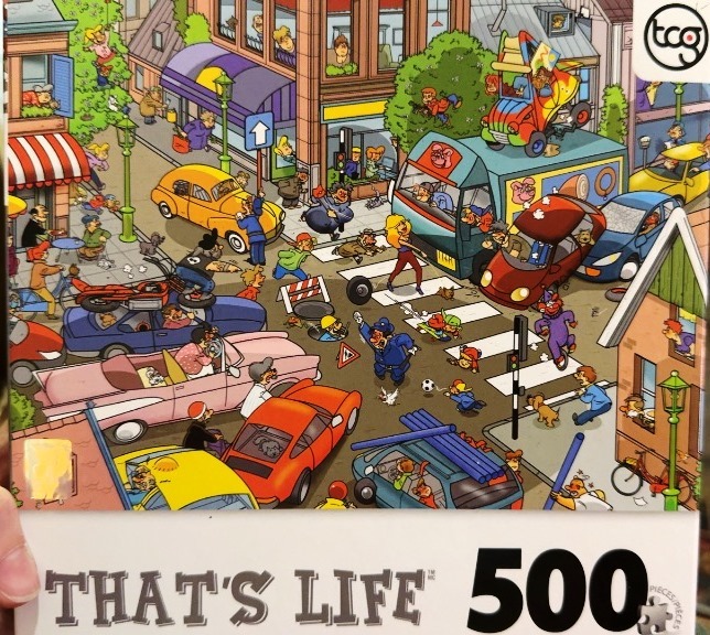 A chaotic, humorous cartoon illustration of a busy city street scene with traffic and pedestrians.