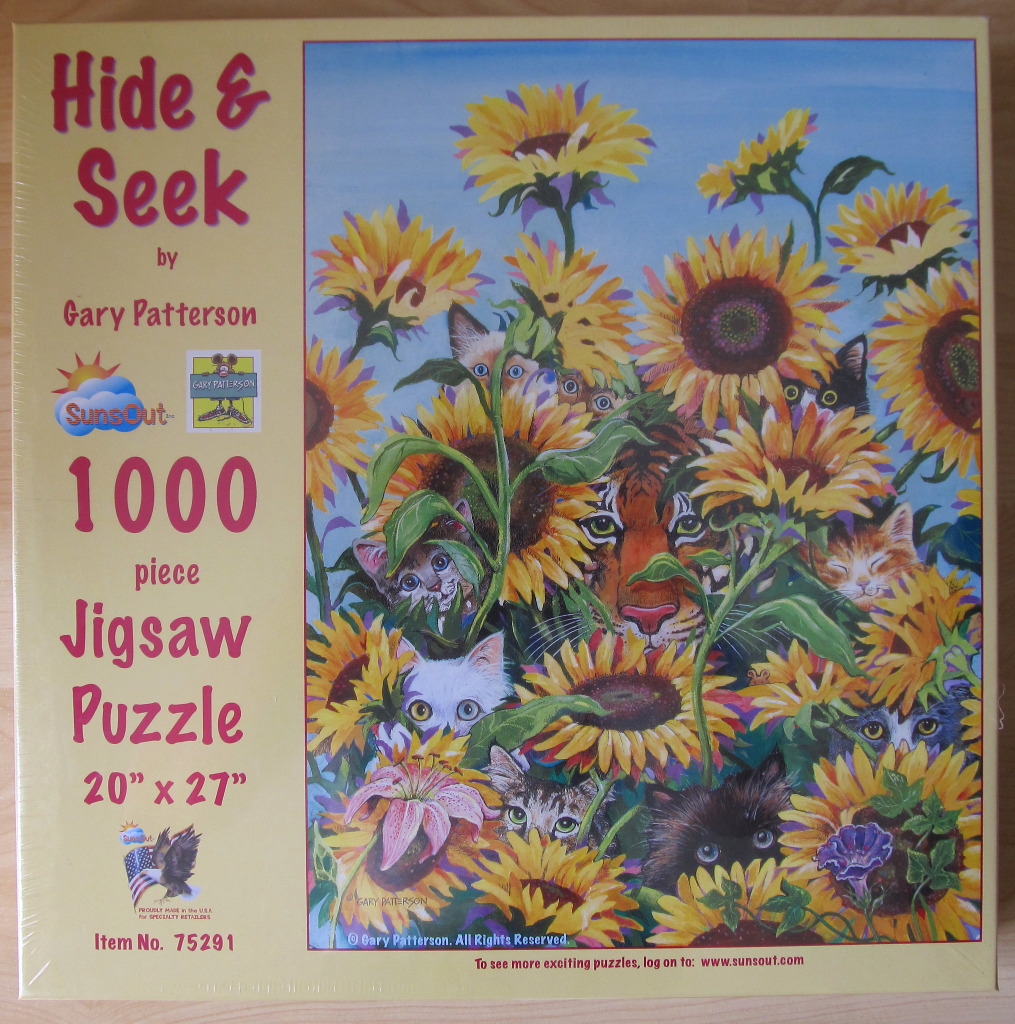 A whimsical illustration of many cats hiding among a field of large sunflowers, with a tiger's face peering from the center.
