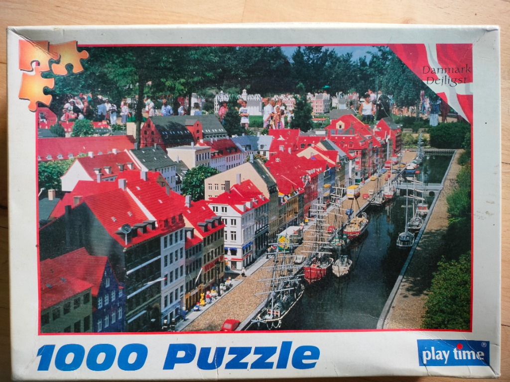 A miniature model of Nyhavn in Copenhagen featuring colorful townhouses and sailing ships along a canal.