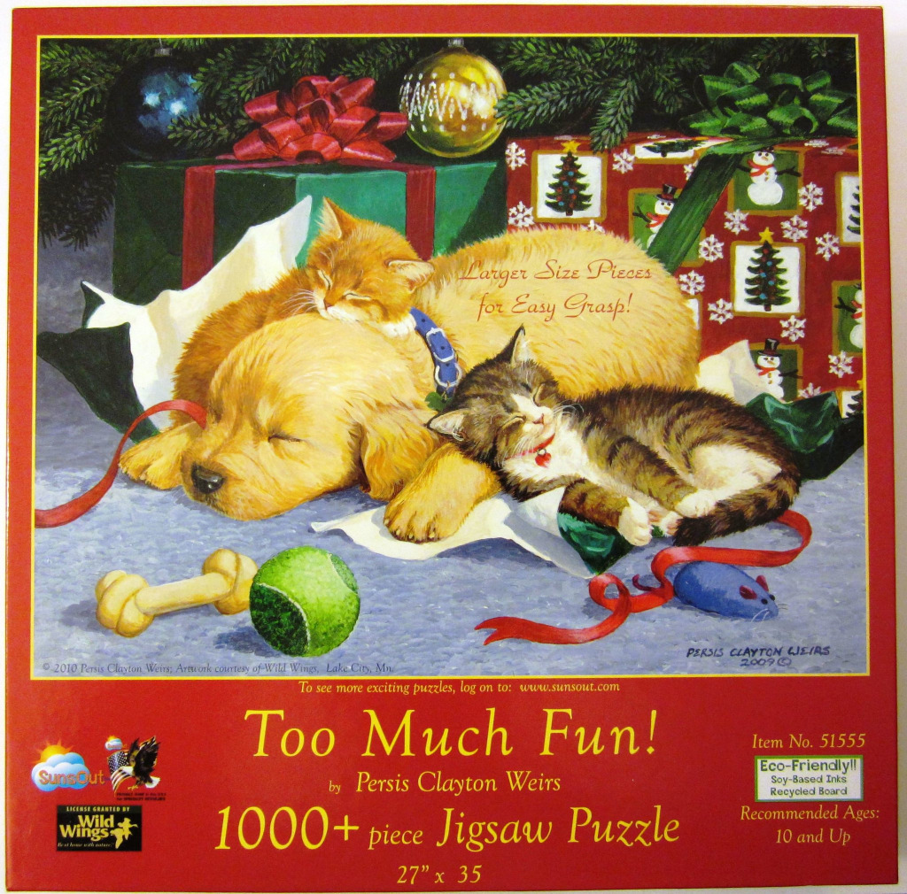 A golden retriever puppy and two kittens sleeping together under a decorated Christmas tree.