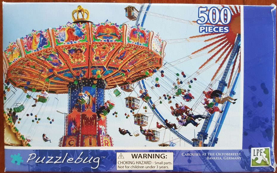 An outdoor swing carousel at the Oktoberfest in Bavaria with riders in motion against a bright sky.