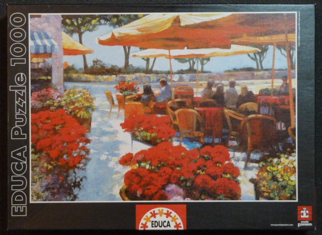 Impressionist oil painting of an outdoor Mediterranean cafe terrace filled with red flowers and umbrellas.