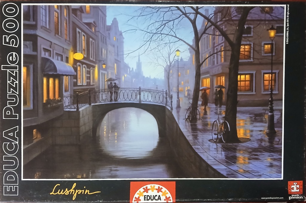 A peaceful canal scene in a European city at dusk with people walking under umbrellas.