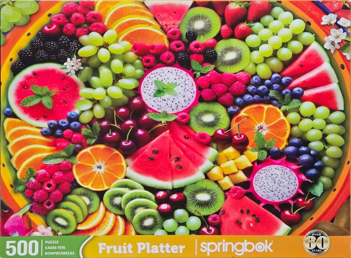 An overhead view of a vibrant, colorful assortment of fresh tropical and summer fruits arranged on a circular platter.