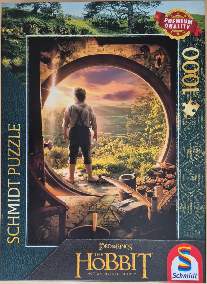 A Hobbit standing in a round doorway looking out over a rolling green landscape at sunset.