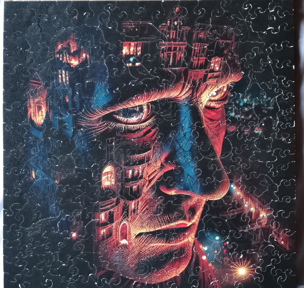 A surreal illustration of a man's face partially formed by a gothic city at night.