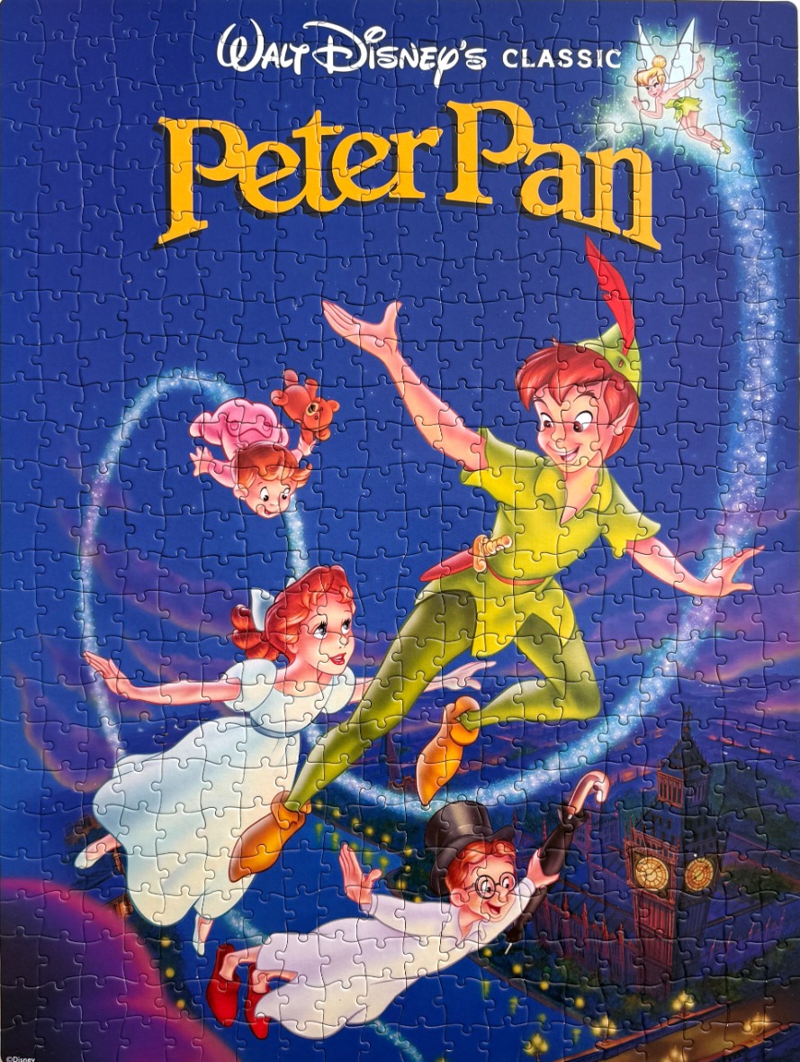 Animated characters Peter Pan, Wendy, John, Michael, and Tinker Bell flying above London at night.