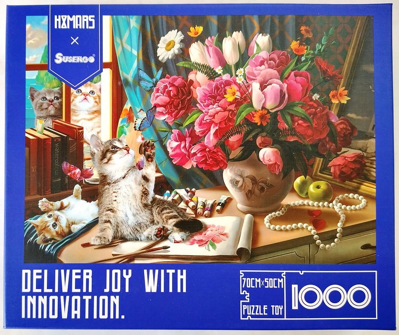 A whimsical illustration of three kittens playing with a bouquet of pink peonies, butterflies, and art supplies.