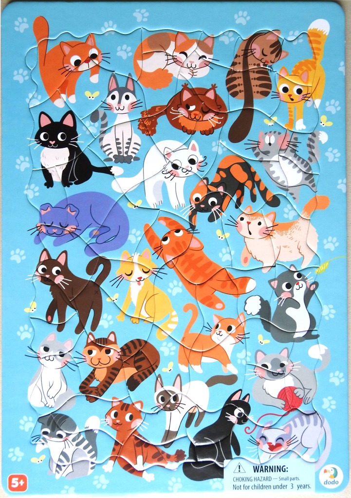 A whimsical illustration of numerous colorful cartoon cats on a light blue background decorated with paw prints.