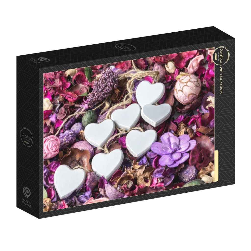 Seven smooth white wooden hearts resting on a bed of dried purple, pink, and burgundy potpourri.