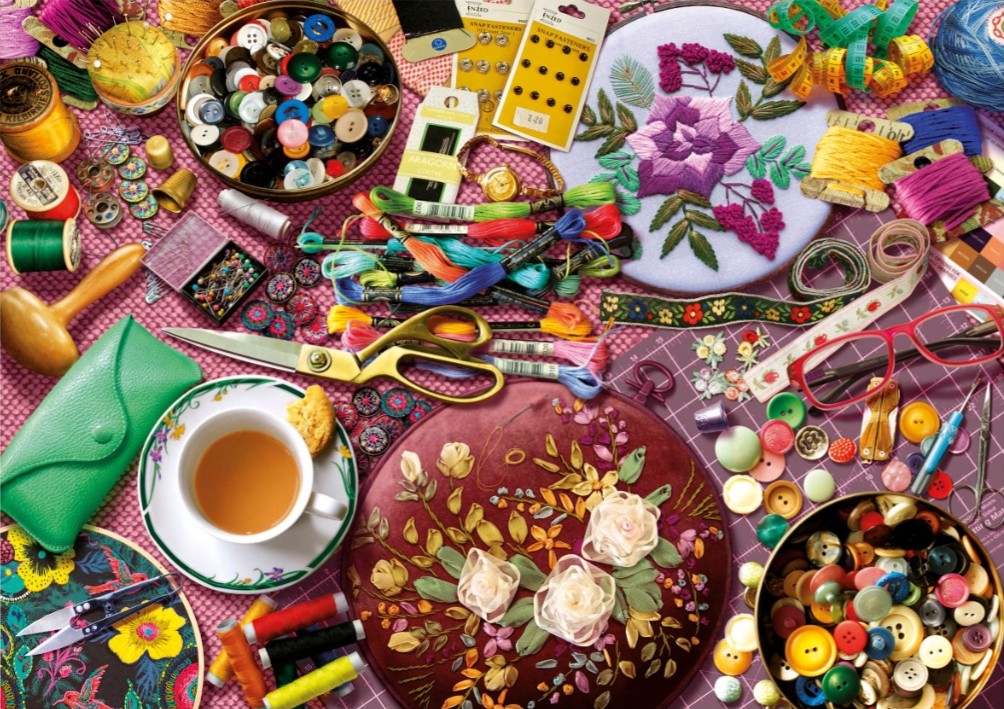 A top-down view of a sewing and embroidery workstation filled with colorful threads, buttons, and hoops.