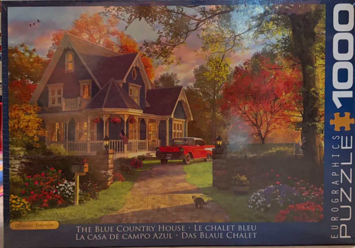 A blue Victorian-style house sits in a lush autumn garden with a vintage red car in the driveway at sunset.