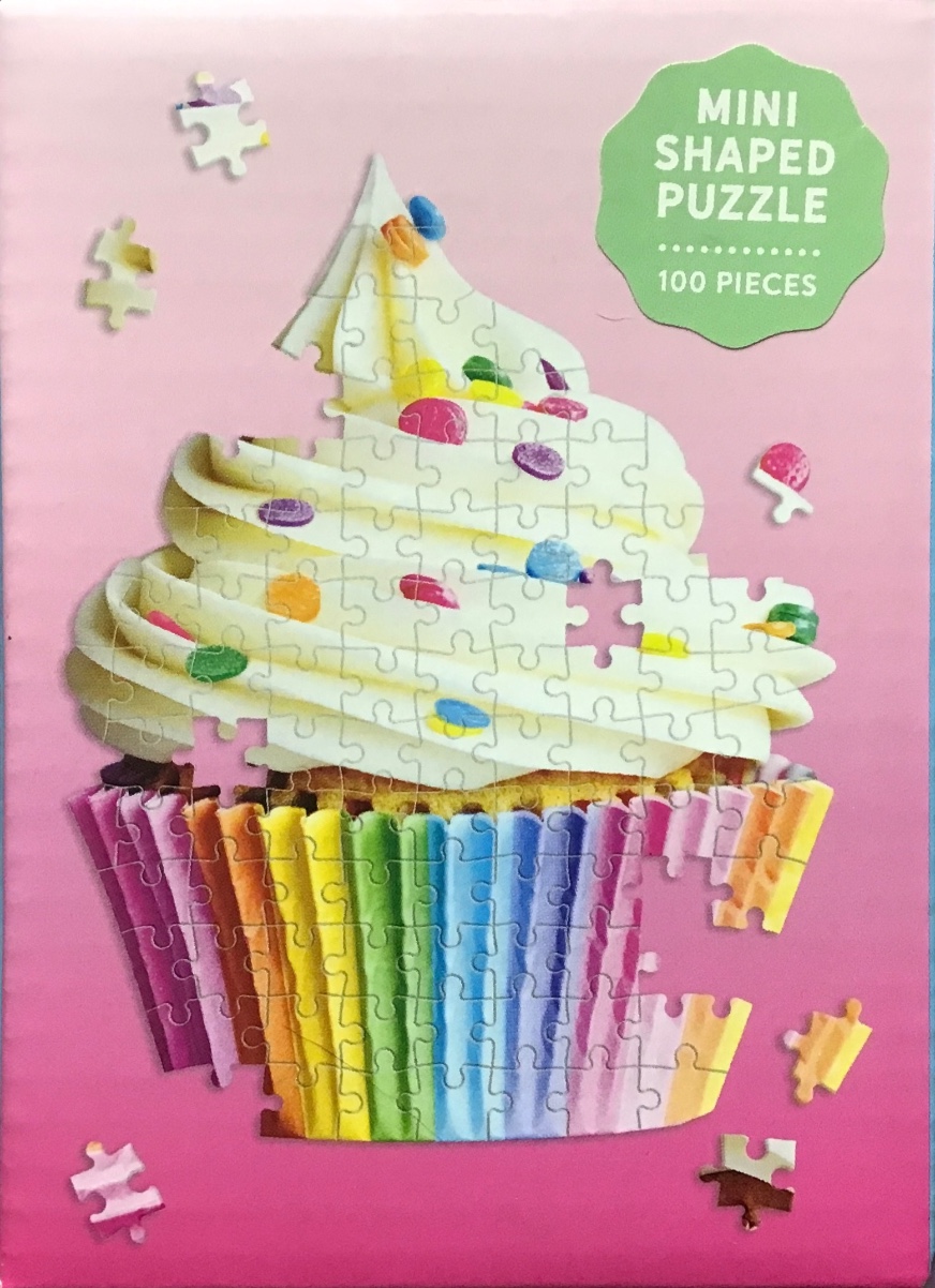 A colourful cupcake with rainbow-striped paper liner and white frosting on a solid pink background.