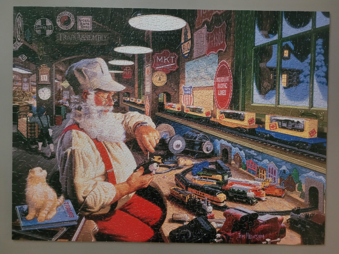 An illustration of Santa Claus in a workshop repairing model trains, with a fluffy cat sitting nearby.