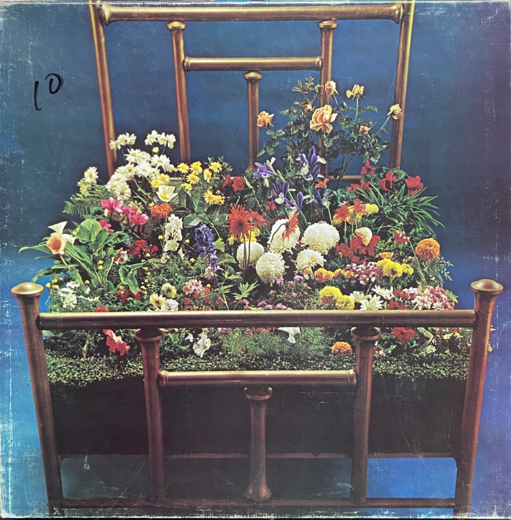 A lush garden filled with colorful flowers growing inside a metal bed frame against a deep blue background.