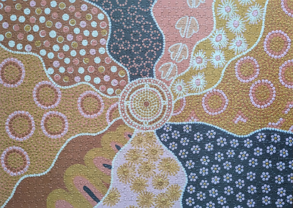 An abstract Indigenous-style dot painting featuring a central circular motif surrounded by segmented organic shapes.