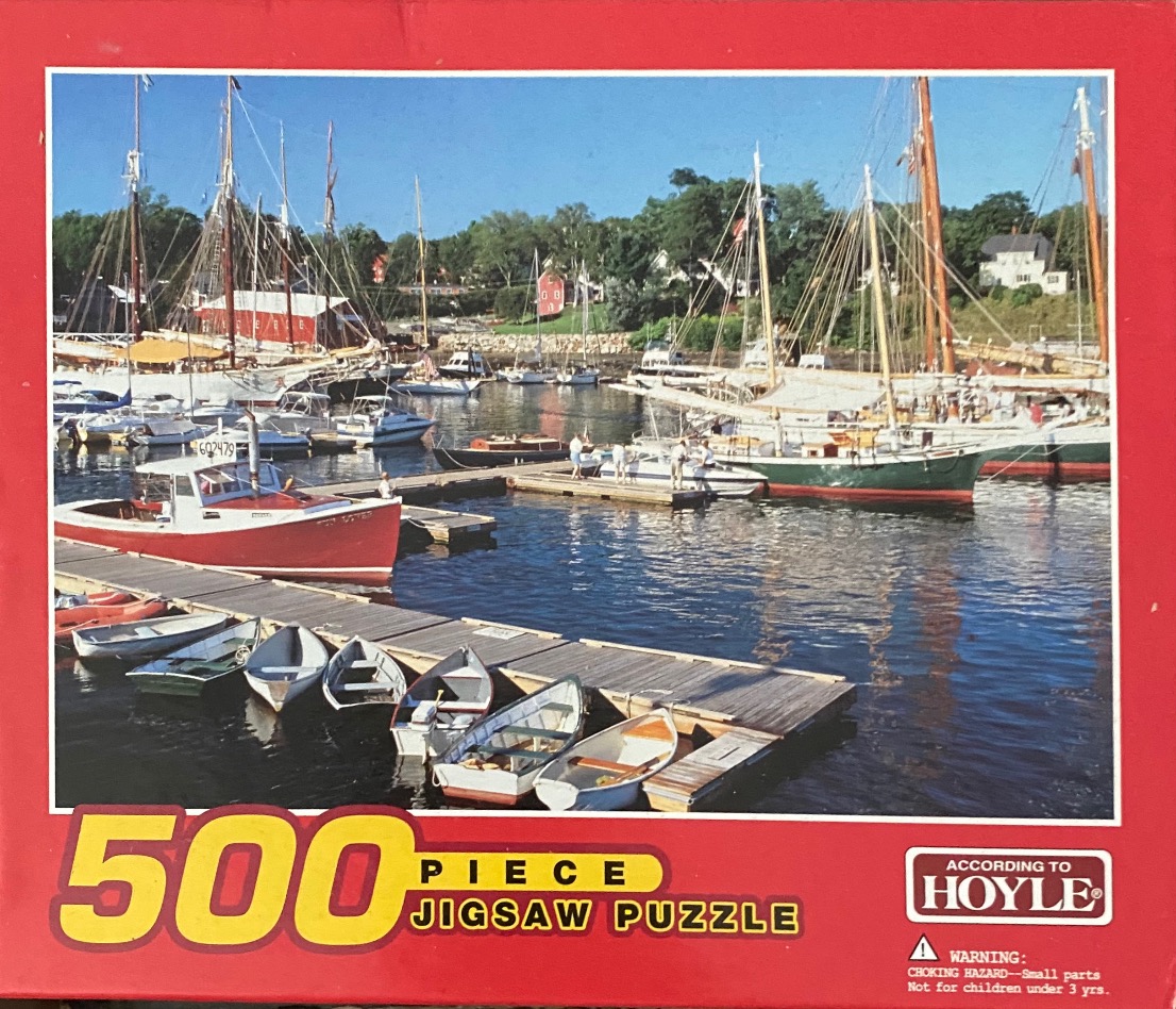 A sunny harbor scene filled with various sailboats and small rowboats moored at wooden docks.