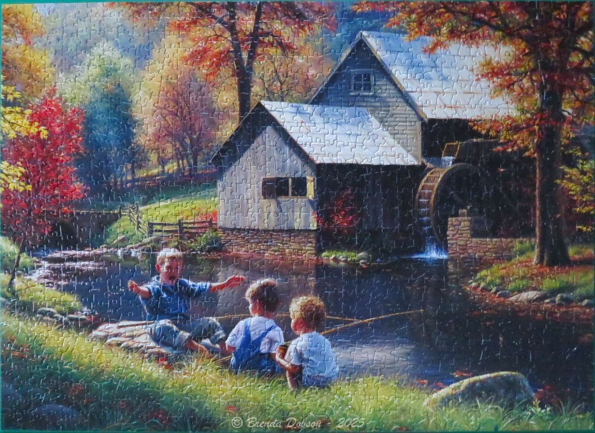 Children fishing at a pond in front of an old mill during autumn