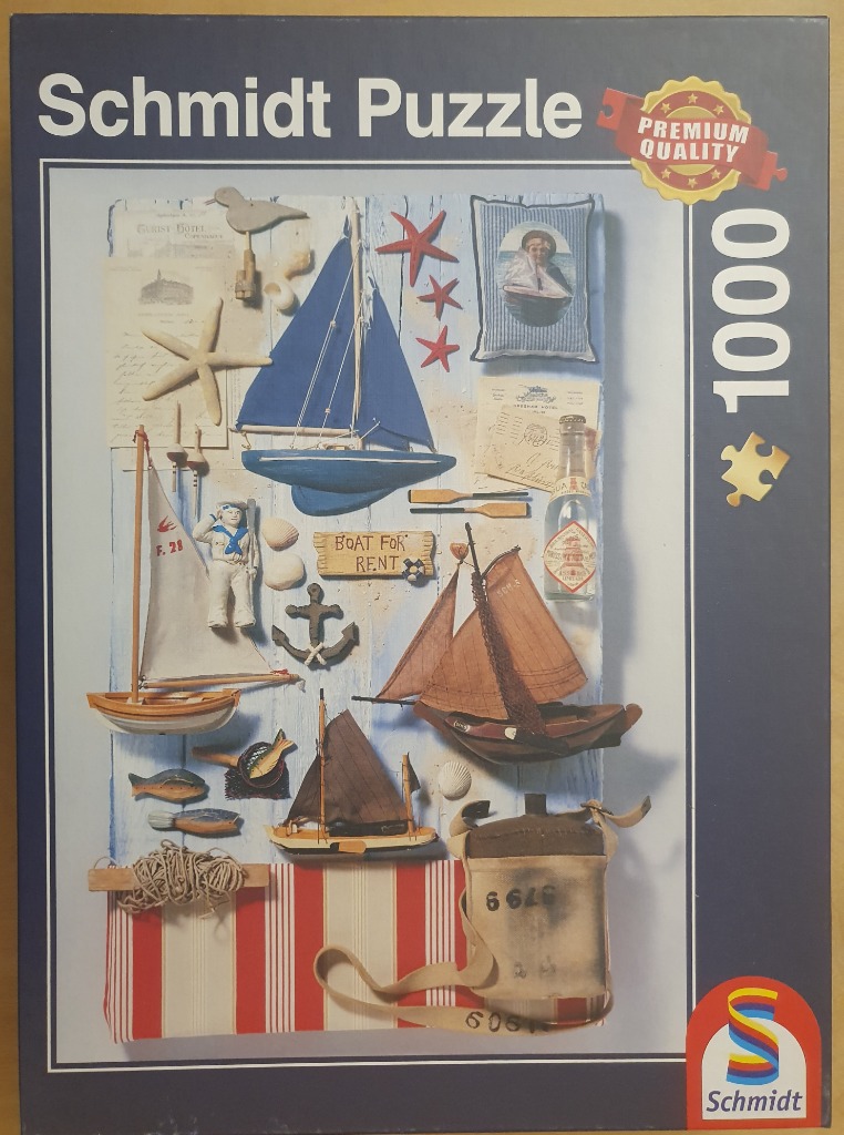 A collection of nautical objects and model sailboats arranged on a light blue wooden background.