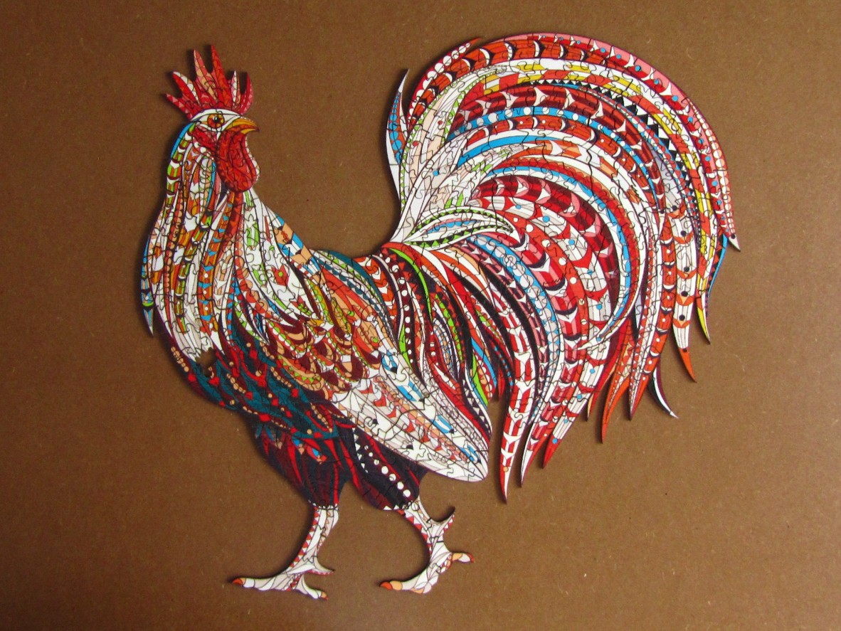 An intricately patterned, colorful rooster silhouette standing against a plain brown background.