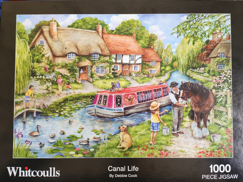 An idyllic English countryside scene featuring a thatched cottage, a canal boat, and people with a horse by the water.