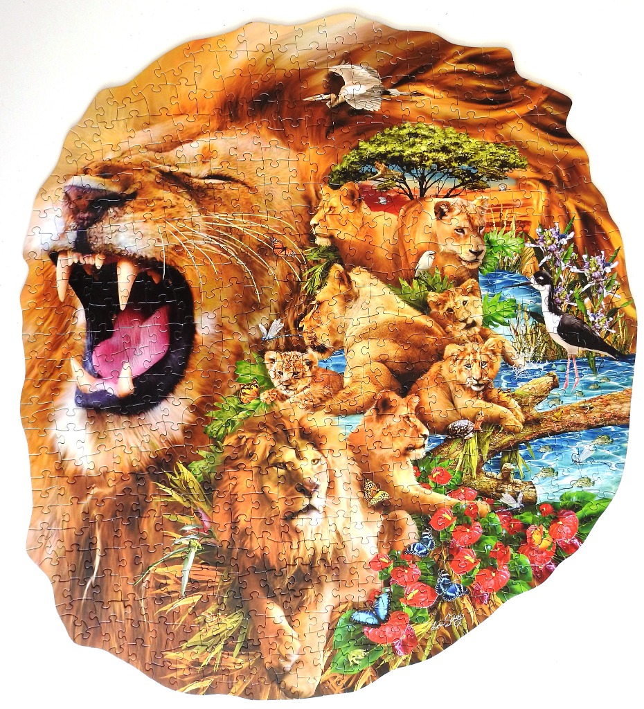A whimsical circular illustration featuring a roaring lion head overlaid on a savanna scene with lions and wildlife.