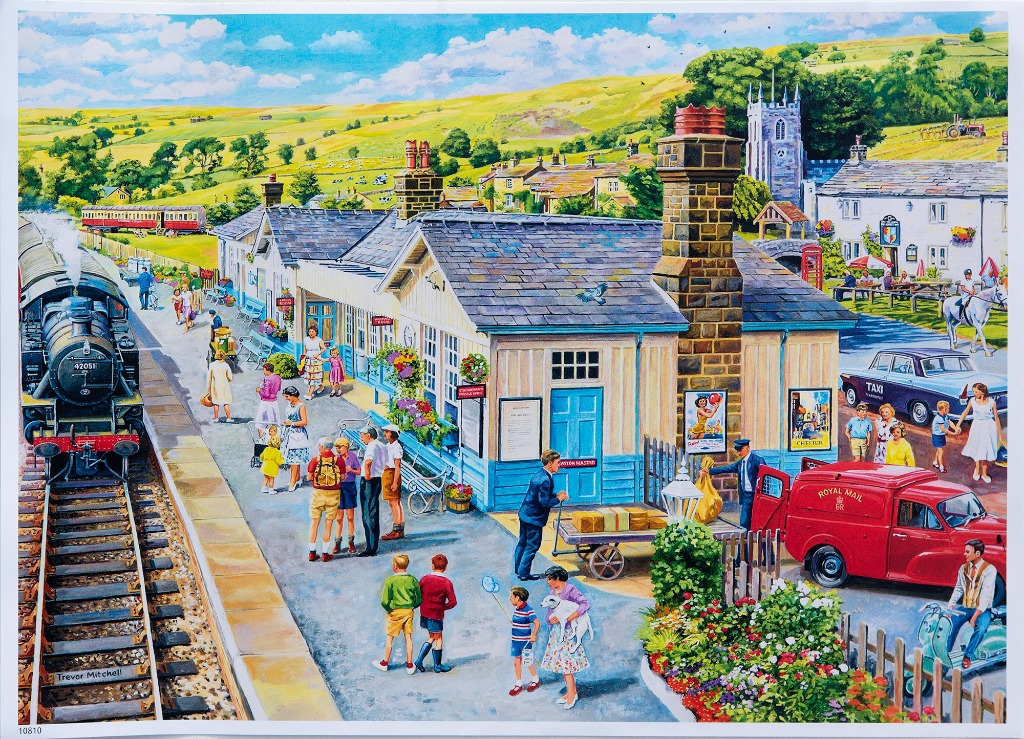 A bustling British village train station scene with a steam locomotive, passengers, and a Royal Mail van.