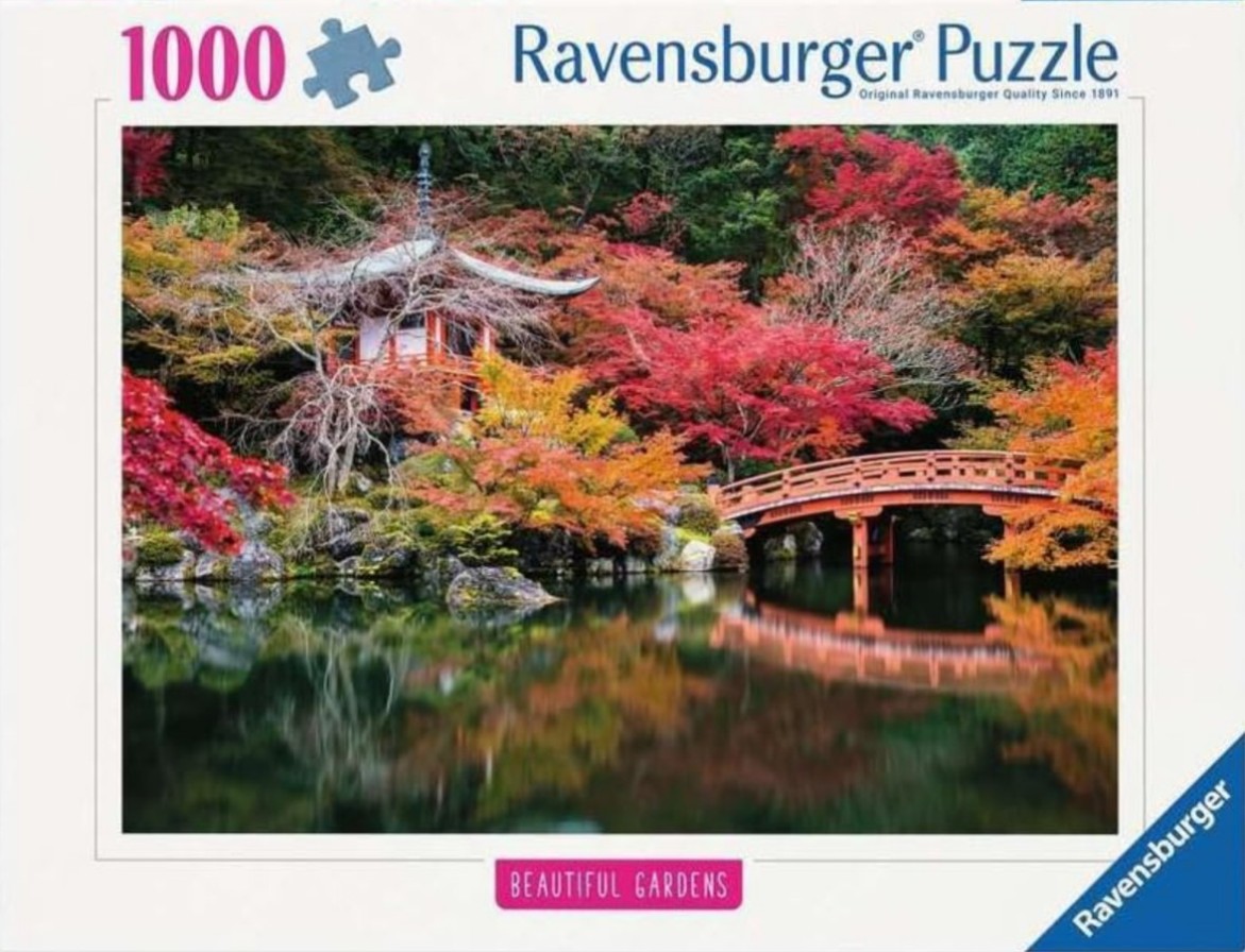 A Japanese-style garden in autumn with a red wooden bridge, a pagoda, and vibrant fall foliage reflected in a pond.