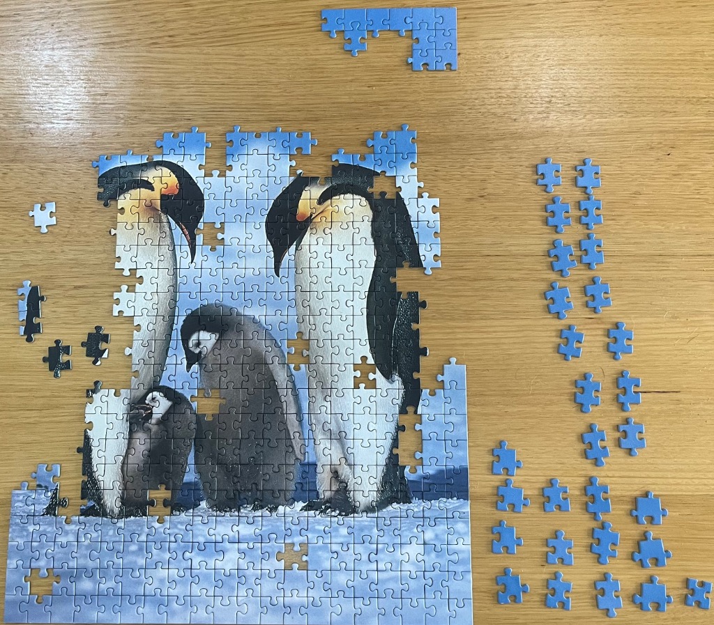 An illustration of three emperor penguins standing in an Antarctic snowscape.