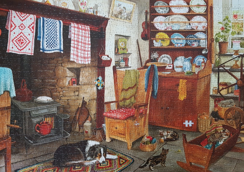 A cozy, rustic country kitchen interior with a stone fireplace, a wood stove, and several pets.
