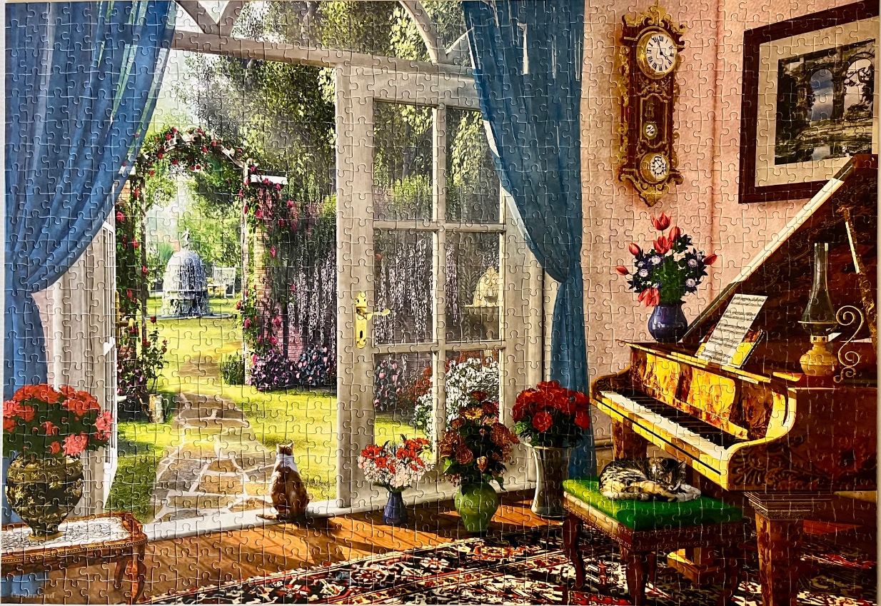 A sunlit parlor with a grand piano and a view of a lush garden through open French doors.