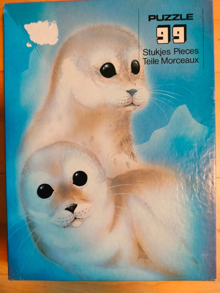 Illustration of an adult harp seal and its pup against a bright blue icy background.
